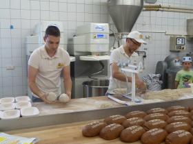 Martin Hodapp und Dominik Schuler beim Aufarbeiten des Jubiläumsbrotes.