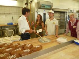 Bürgermeister Siefermann beim Abstauben des Jubiläumsbrotes.